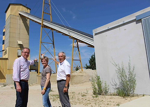 Ansicht der Photovoltaikanlage Betonwerk mit drei Personen im Vordergrund.